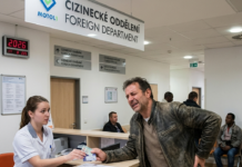 Sanità a Praga: Guida a Medici, Dentisti e Pronto Soccorso (Aggiornamento 2026) Un uomo italiano dolorante presenta i suoi documenti alla reception del Cizinecké oddělení (Dipartimento Stranieri) dell'Ospedale Motol di Praga, 2026.